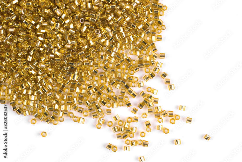 A scattering of Golden matte beads on a white background A scattering of Golden matte beads on a white background