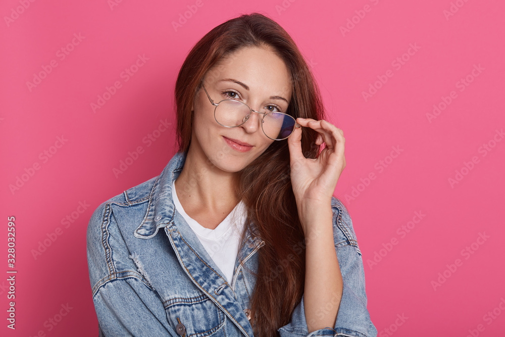 Φωτογραφία Studio shot of cute caucasian female with dark hair posing isolated over pink background