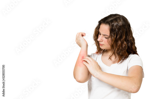 Young teenager scratching an itchy hand on white background