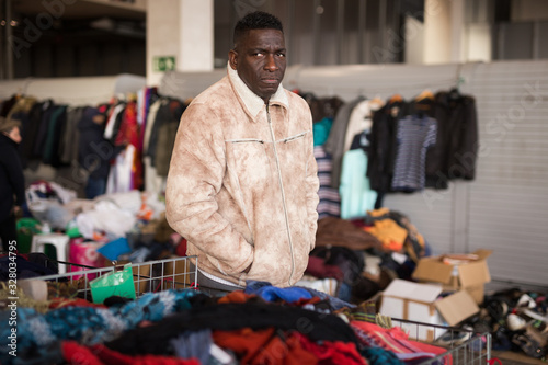 Afro-American guy sells sacond hands clothes on flea market