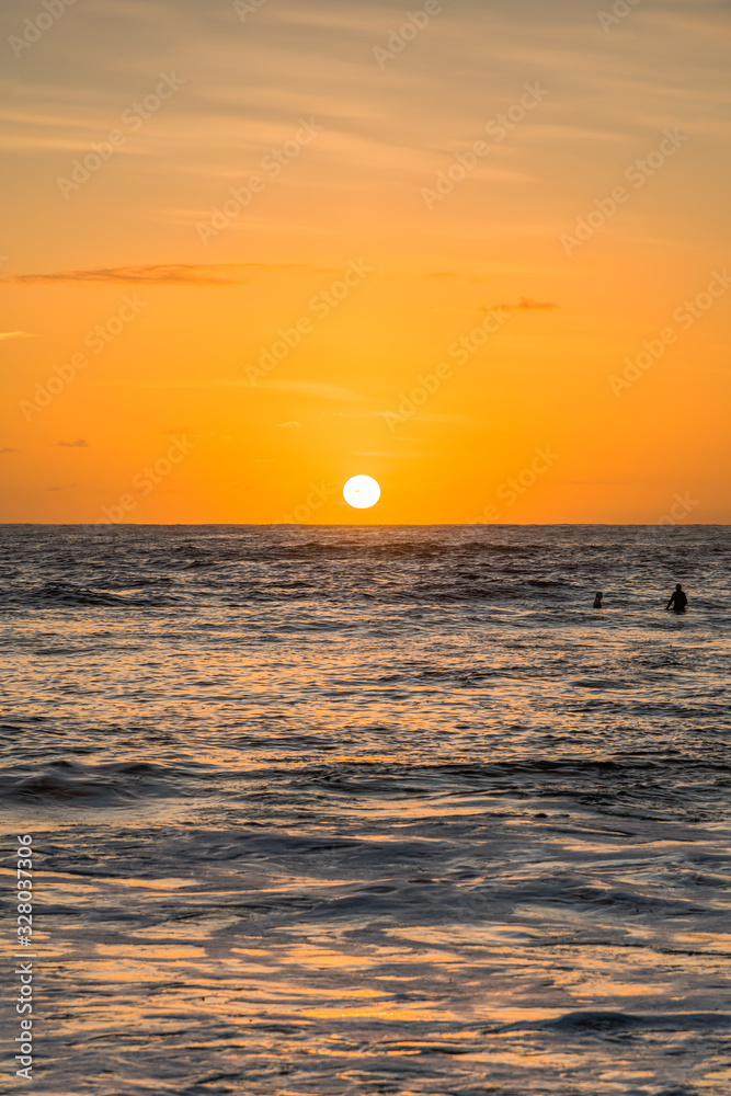 Sunrise Seascape and Surfers waiting for a wave