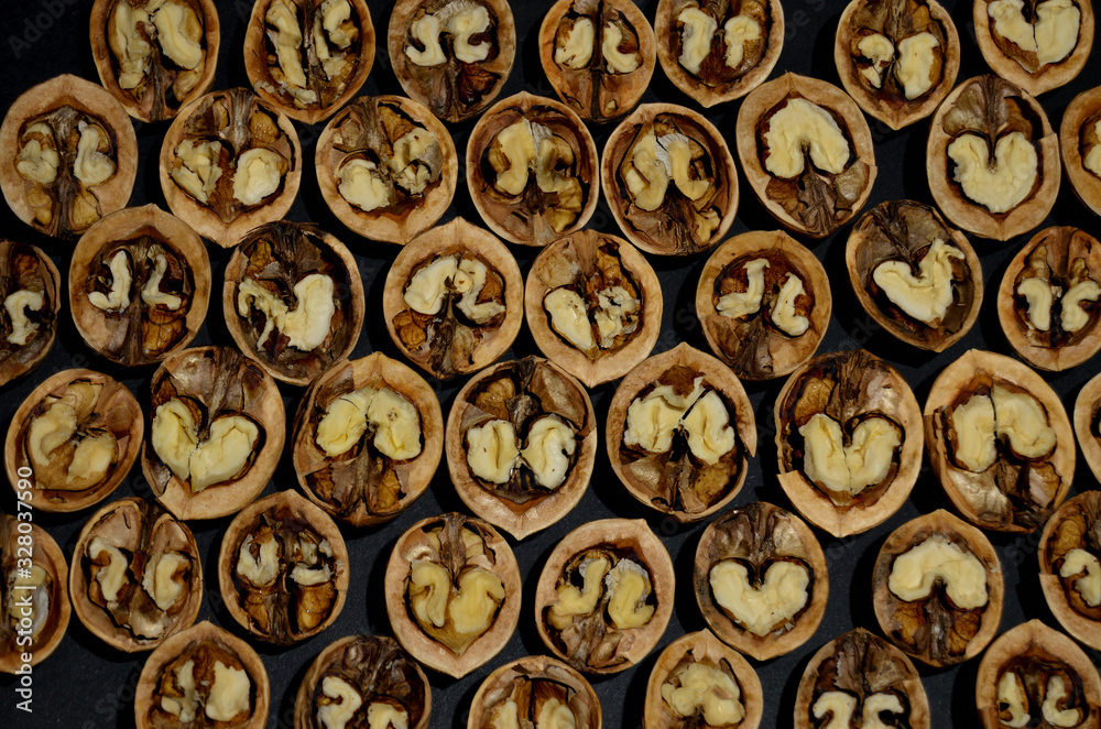 inshell walnut halves pattern on a black background horizontal orientation