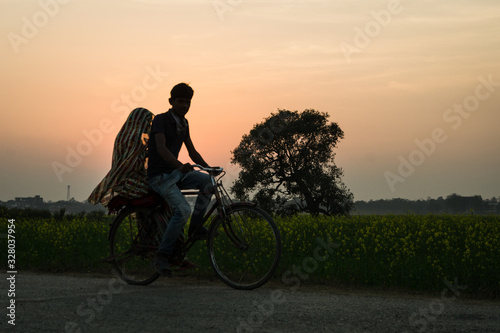 Pareja viajando en bicicleta por el campo al atardecer en Nepal