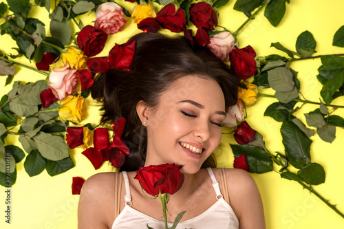 prettiest girl with red rose in hands in the rosery background photo