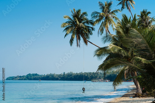 Fototapeta Naklejka Na Ścianę i Meble -  Tropical island beach landscape with a palm trees in Thailand. Crystal clear water against blue sky background. Wallpaper. Vacation