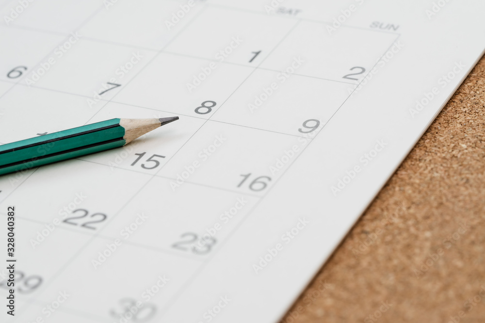 Closed up of pencil on calendar on wooden table using as writing agenda or important memo and appointment and planning on calendar Closed up of pencil on calendar on wooden table using as writing agenda or important memo and appointment and planning on calendar