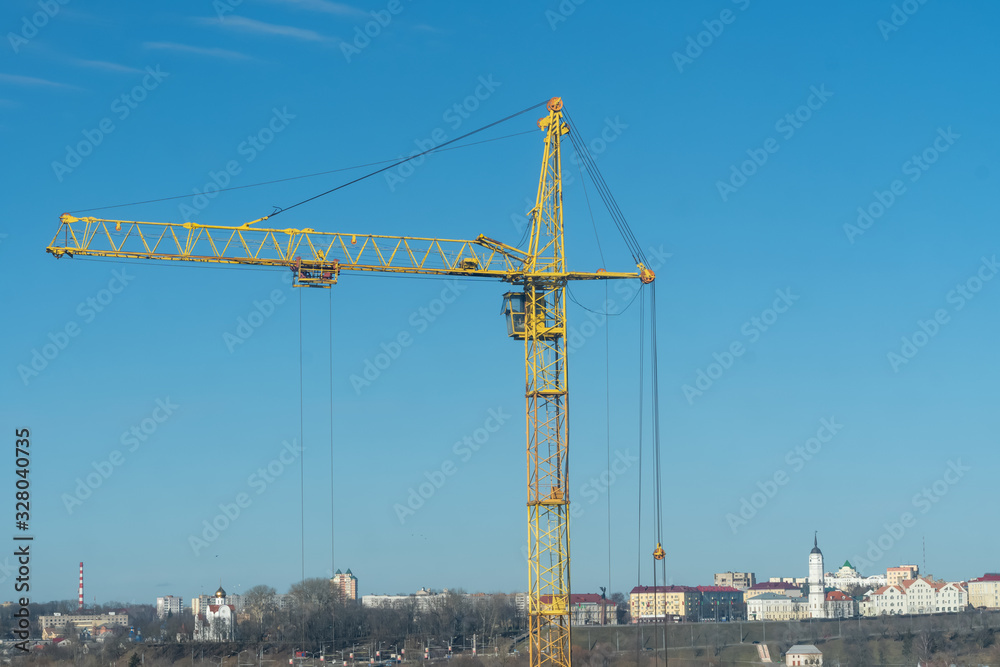 yellow crane, crane on the background of the city and blue sky with clouds close-up, copy space
