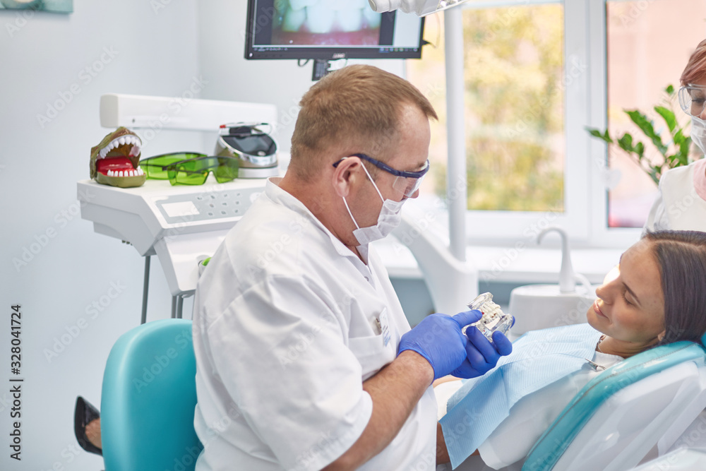 Doctor dentist treats teeth of a beautiful young girl patient. The girl on reception at the dentist. Doctor dentist treats tooth Doctor dentist treats teeth of a beautiful young girl patient. The girl on reception at the dentist. Doctor dentist treats tooth