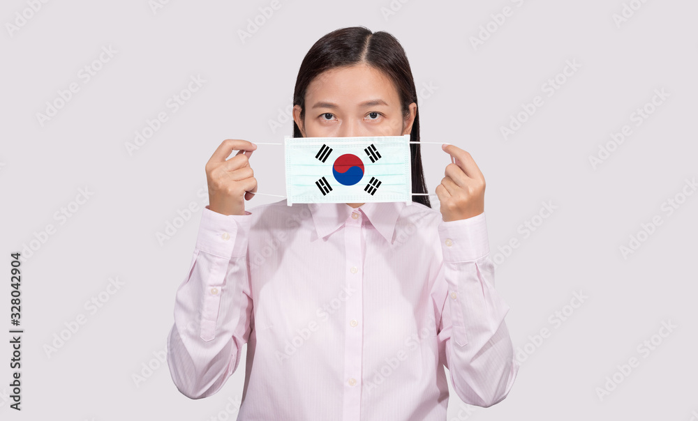 Asian woman wearing hygienic face mask painting South Korea flag to protect from the Coronavirus 2019 (COVID-19) infection outbreak situation, the virus originated from Wuhan, China. Asian woman wearing hygienic face mask painting South Korea flag to protect from the Coronavirus 2019 (COVID-19) infection outbreak situation, the virus originated from Wuhan, China.
