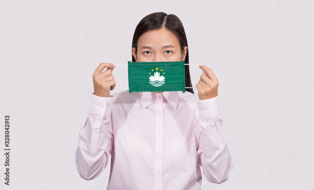 Asian woman wearing hygienic face mask painting Macau flag to protect from the Coronavirus 2019 (COVID-19) infection outbreak situation, the virus originated from Wuhan, China. Asian woman wearing hygienic face mask painting Macau flag to protect from the Coronavirus 2019 (COVID-19) infection outbreak situation, the virus originated from Wuhan, China.