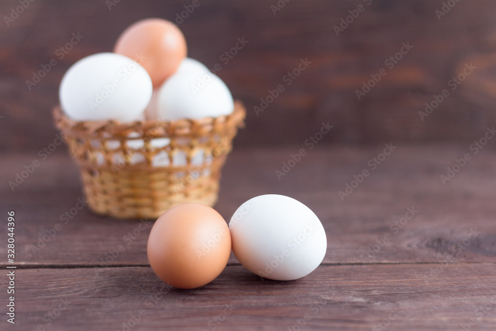 White and brown chicken eggs on a dark wooden background. White and brown chicken eggs on a dark wooden background.