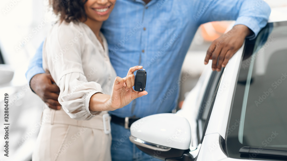 Unrecognizable Couple Showing New Car Key Hugging In Dealership, Panorama Unrecognizable Couple Showing New Car Key Hugging In Dealership, Panorama