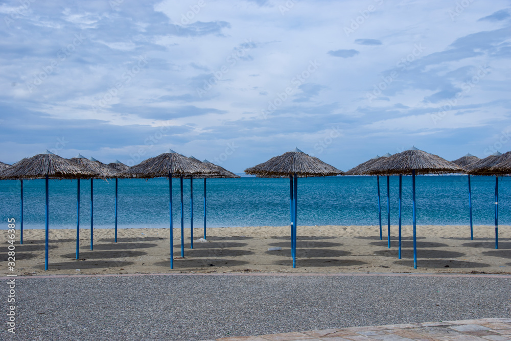 Reed umbrellas in empty beach in Peraia, of Thessaloniki, Greece