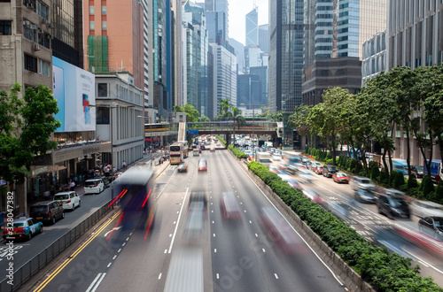 Hong Kong street roads with green palms on median © Yan