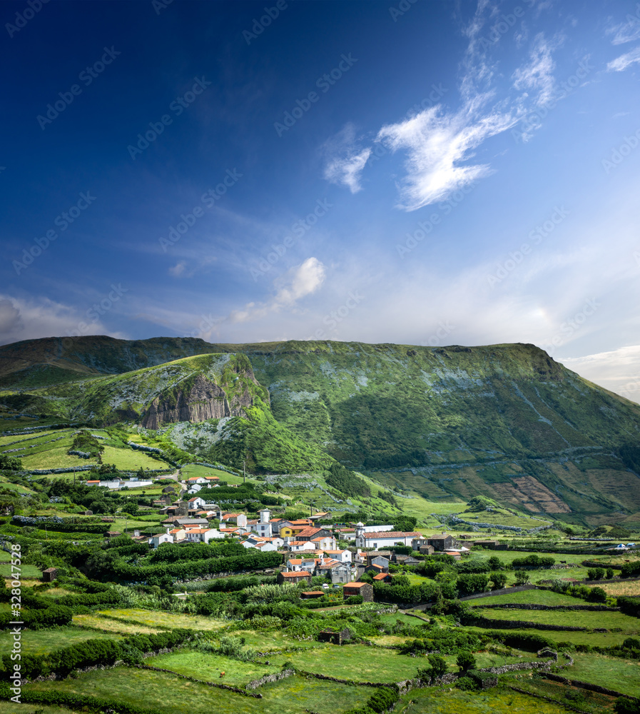 Azores landscape: The village of Mosteiro on the island of Flores, the Azores, Portugal, with on the background Rocha dos Bordoes, a volcanic Basalt rock.
