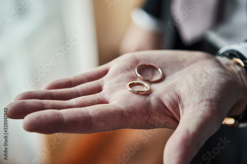 man holding wedding rings, groom getting ready in the morning before ceremony