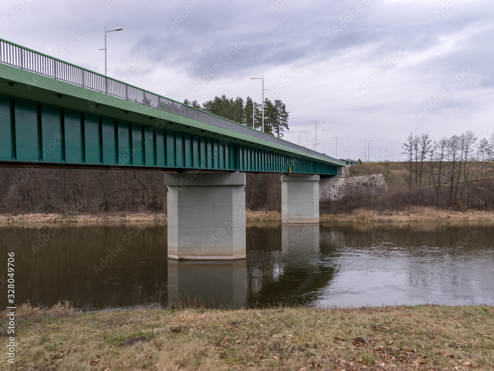 landscape with green bridge over slow flowing river