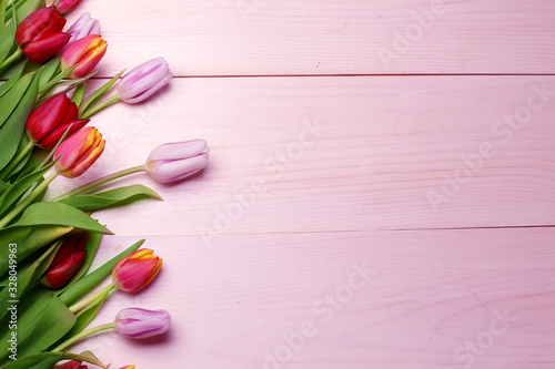Spring flowers composition on the wooden background.Top view colorful tulips  on a wooden surface. Copy space.