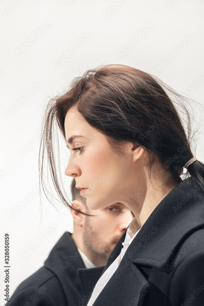 Faces. Trendy fashionable couple isolated on white studio background. Caucasian woman and man posing in basic minimal black stylish clothes. Concept of relations, fashion, beauty, love. Copyspace. Faces. Trendy fashionable couple isolated on white studio background. Caucasian woman and man posing in basic minimal black stylish clothes. Concept of relations, fashion, beauty, love. Copyspace.