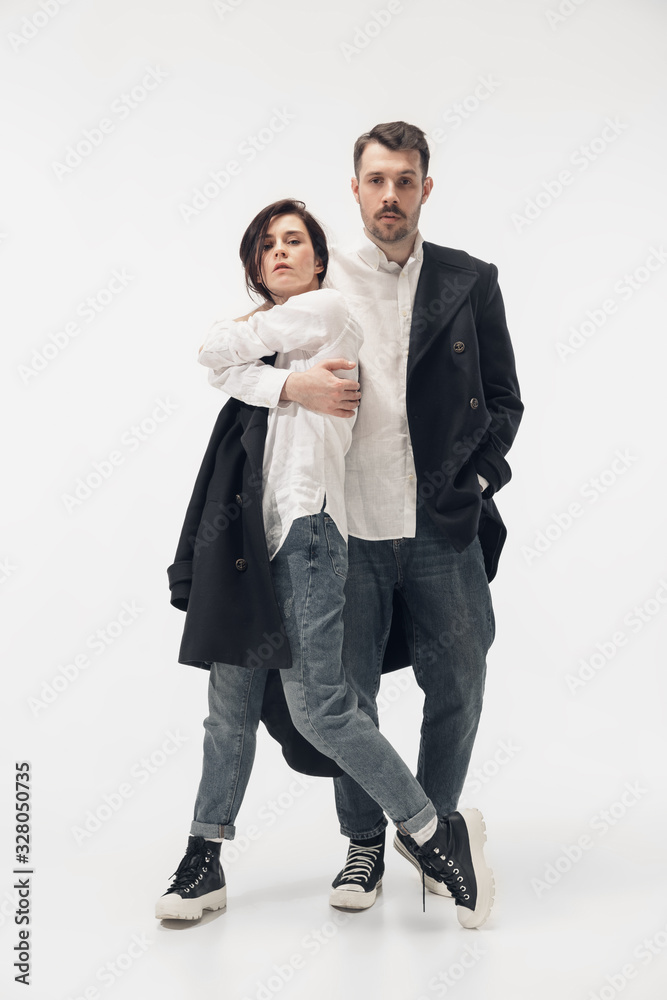Near by. Trendy fashionable couple isolated on white studio background. Caucasian woman and man posing in basic minimal black stylish clothes. Concept of relations, fashion, beauty, love. Copyspace. Near by. Trendy fashionable couple isolated on white studio background. Caucasian woman and man posing in basic minimal black stylish clothes. Concept of relations, fashion, beauty, love. Copyspace.