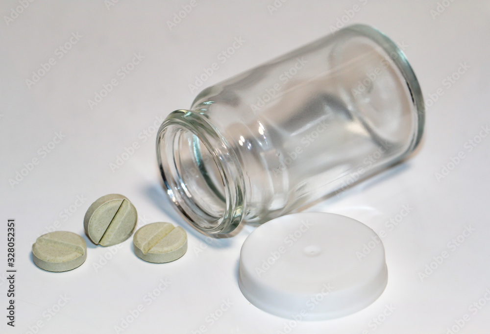 verschiedene Tabletten, Kabseln fallen aus einer Glasflasche verschiedene Tabletten, Kabseln fallen aus einer Glasflasche