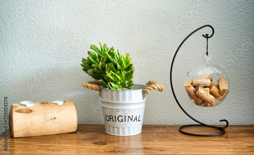 Home decoration with a handmade candle holder, a succulent plant called Crassula Ovata Gollum and a small wine cork vase on a wooden table photo