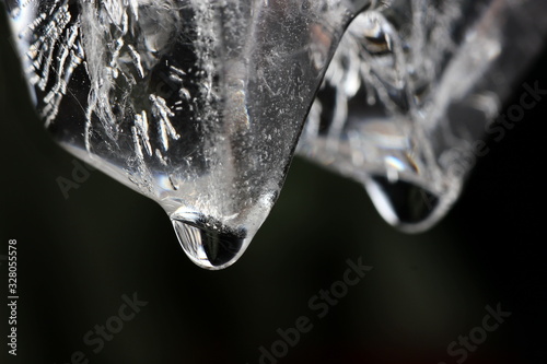 a drop of water in close up hovering on the melting ice