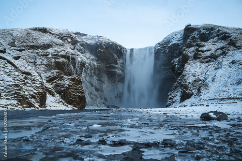 Skogafoss Waterfall in Icelandic Cold Winter. Beautiful Fall. Snowy Background.
