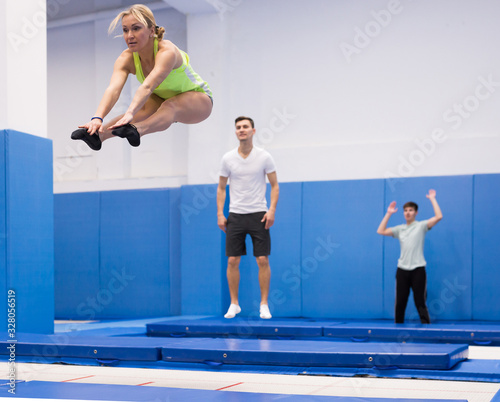 Woman jumping in trampoline center © JackF