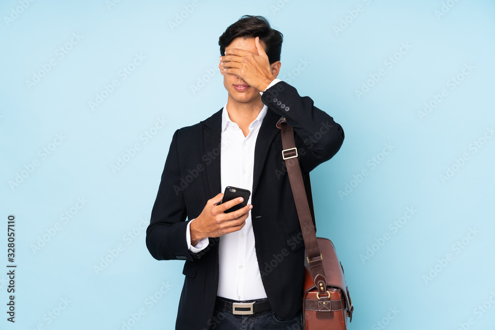 Businessman over isolated blue background covering eyes by hands Businessman over isolated blue background covering eyes by hands
