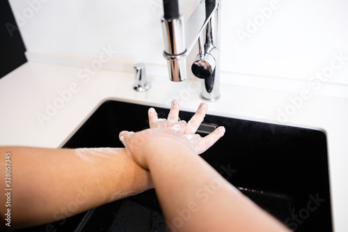 young woman washes hands in hospital to clean virus