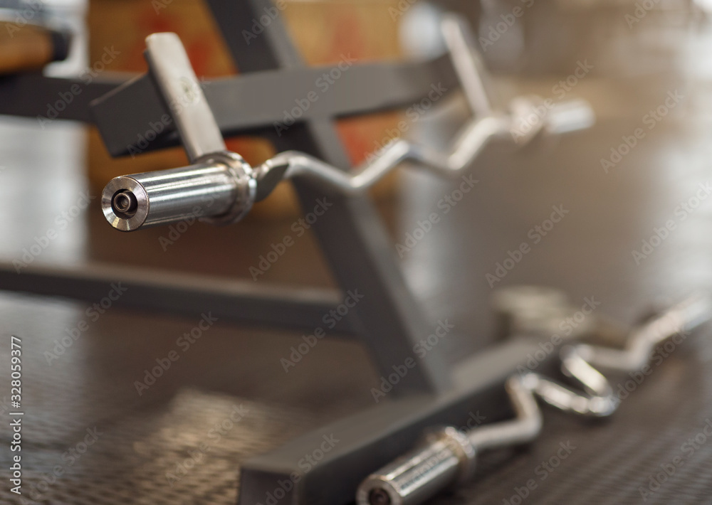 Barbell on stand in sports club, empty space