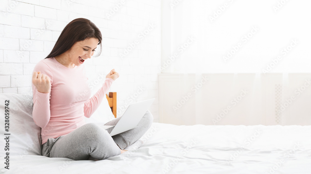 Excited young woman receiving good news online in laptop Excited young woman receiving good news online in laptop