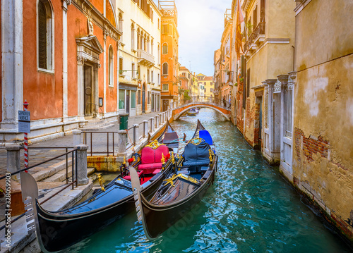 Fotografiet Narrow canal with gondola and bridge in Venice, Italy