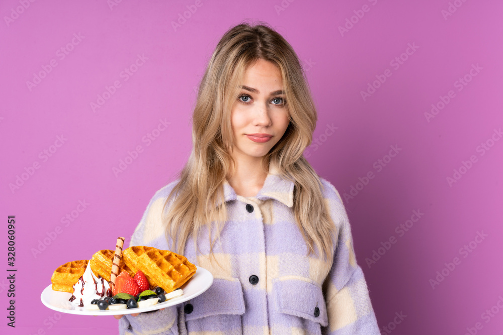 Teenager Russian girl holding waffles isolated on purple background with sad and depressed expression Teenager Russian girl holding waffles isolated on purple background with sad and depressed expression