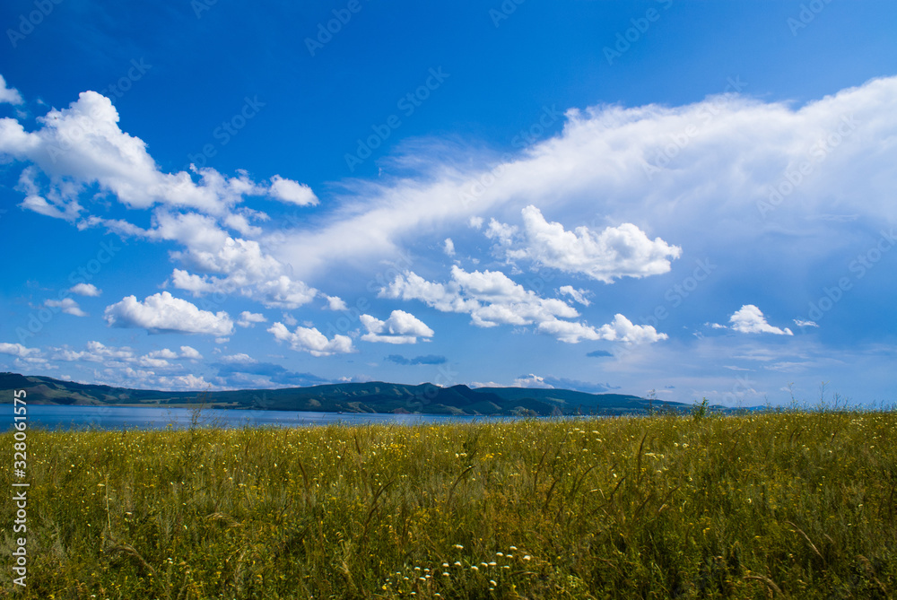Blue sky over the flowering steppe and Siberian river.