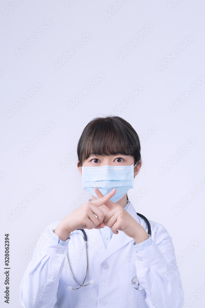 Young female doctor woman wearing mask, making stop sign gesture, saying No isolated on white background, refusing virus disease, close up, blank.