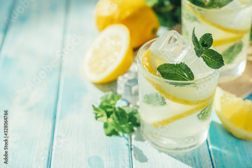 Lemonade and ingredients on blue wood background, copy space