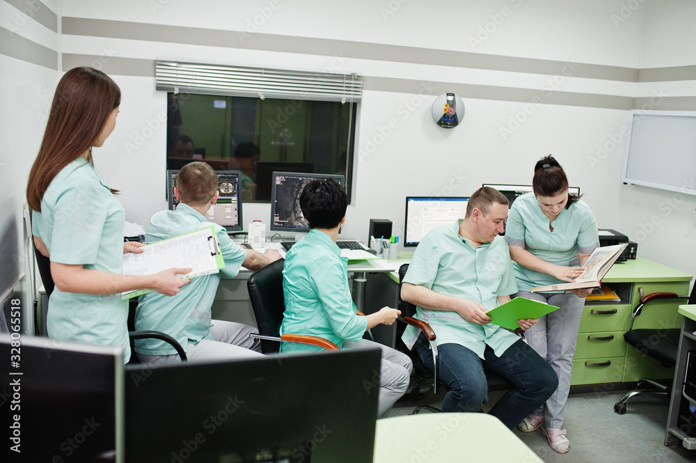 Obraz premium Medical theme.Observation room with a computer tomograph. The group of doctors meeting in the mri office at diagnostic center in hospital.