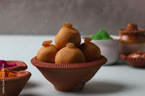 Popular Indian Sweet Besan Laddoo or gram flour sweet balls popular Holi snacks served in earthen bowls. (Holi Food Concept)