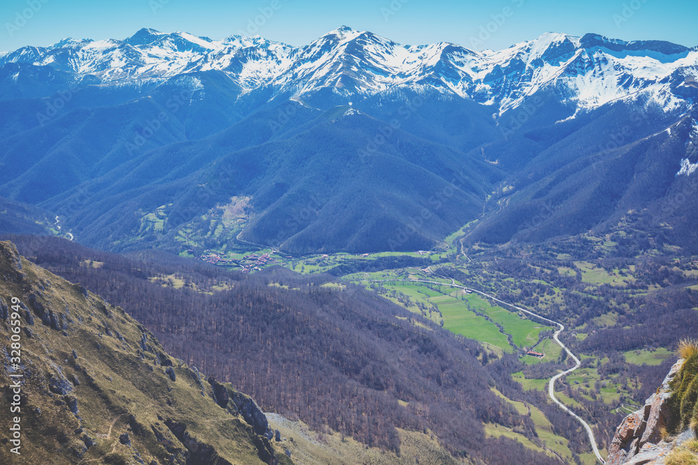 Panoramic view at valley against a mountain range covered with snow. National park Peaks of Europe (Picos de Europa). Aerial view. Fuente De, Cantabria, Spain, Europe