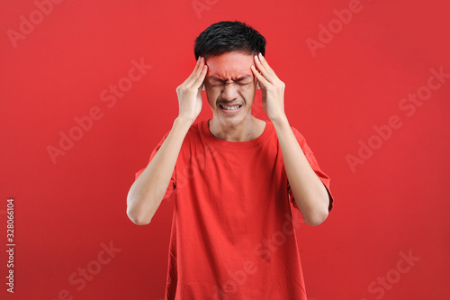 Canvas Print Young Asian man suffering from vertigo headache, A studio portrait of a painful
