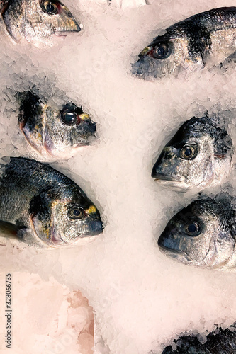A lot of fresh fish in ice at the fish market counter. Food background. Healthy food. Wild animals © serebryannikov