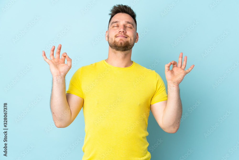 Russian handsome man isolated on blue background in zen pose - obrazy, fototapety, plakaty 