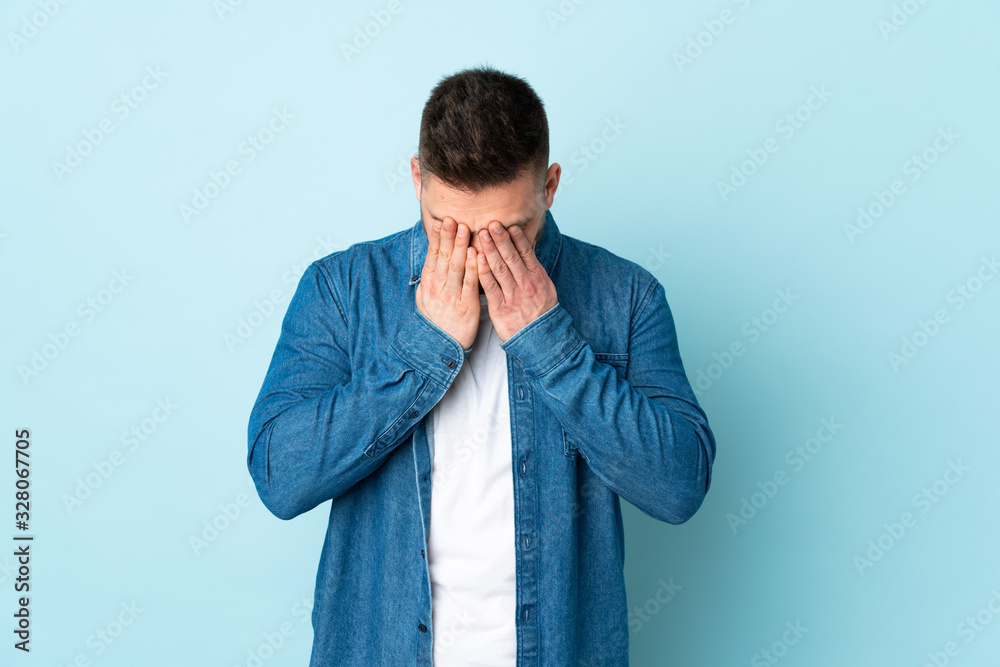 Russian handsome man isolated on blue background with tired and sick expression