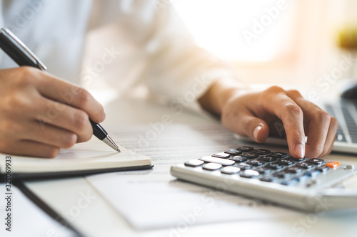 close up hands of accountant using calculator count balance of company.