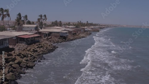 Approaching aerial drone view move of houses on Colan Beach at a sunny day in Piura Region, Peru photo