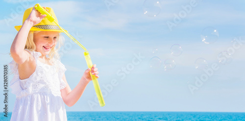 Little girl with soap bubbles on the sea