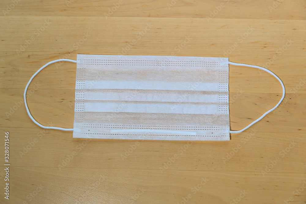 Photo of white medical face mask against virus on the table Photo of white medical face mask against virus on the table