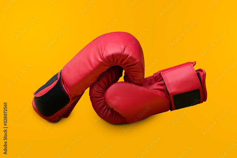 Pair of red leather boxing gloves isolated on red background with copy space